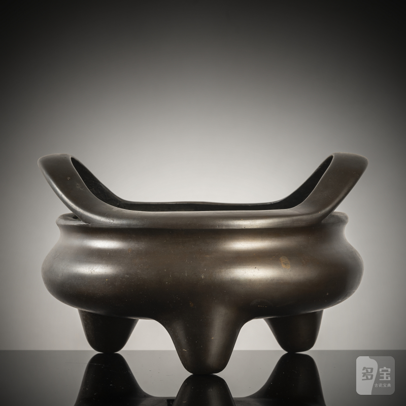 A tripod bronze incense burner with handles on the rim